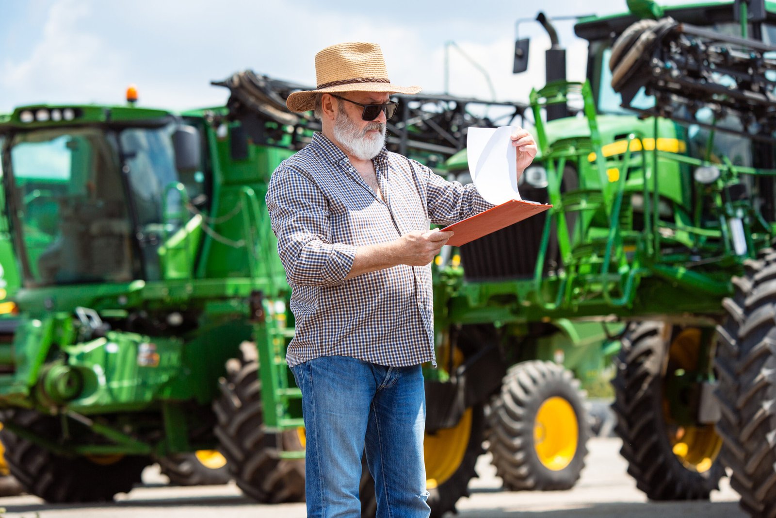 a farmer with a tractor, combine at a field in sunlight. confident, bright colors